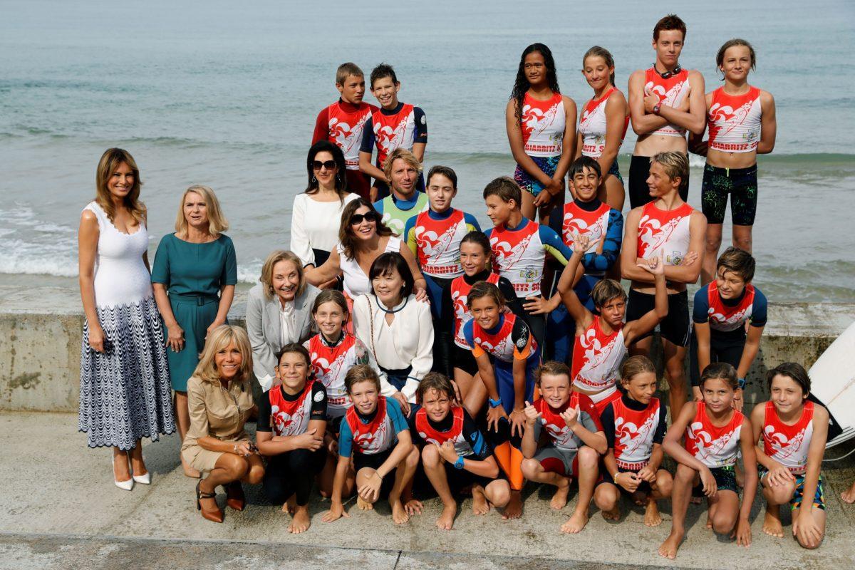 (From L) US First Lady Melania Trump, European Council President's wife Malgorzata Tusk, French President's wife Brigitte Macron, Chile's First Lady Cecilia Morel, President of the World Bank Group's wife Adele Malpass, Australia's Prime Minister's wife Jenny Morrison and Japan's Prime Minister's wife Akie Abe pose with surf students during a meeting with surfers at the Cote des Basques beach as part of the G7 summit, in Biarritz, France on Aug. 26, 2019. (THOMAS SAMSON/AFP/Getty Images)
