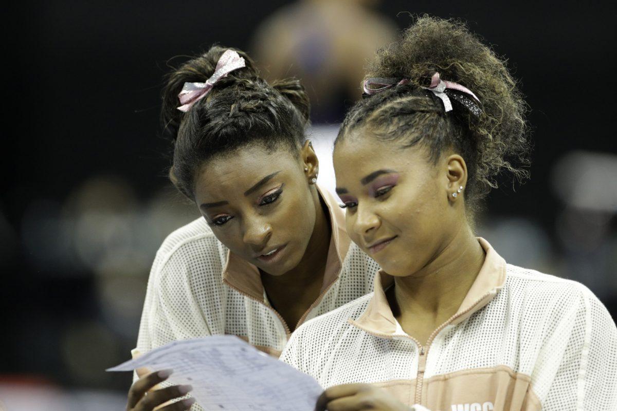 Simone Biles, left, and Jordan Chiles look over a rotation schedule during practice for the senior women's competition at the 2019 U.S. Gymnastics Championships on Aug. 11, 2019, in Kansas City, Mo. (Charlie Riedel/AP Photo)