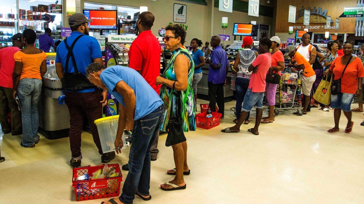 Residents stand in line at a grocery store as they prepare for the arrival of Tropical Storm Dorian, in Bridgetown, Barbados on Aug. 26, 2019. (AP Photo/Chris Brandis)