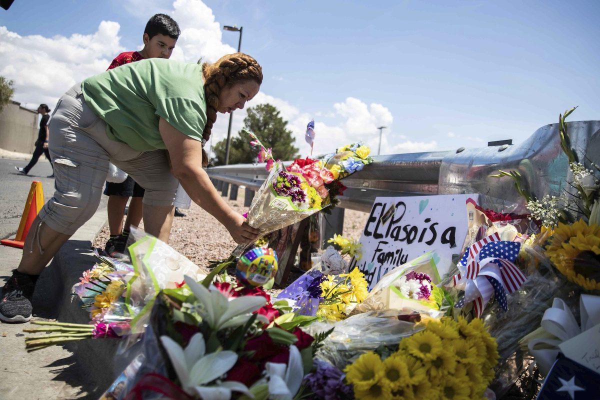Carmen Roldan brings some flowers to honor the memory of the victims of the mass shooting occurred in Walmart on Saturday morning in El Paso on Aug. 4, 2019. (Lola Gomez/Austin American-Statesman via AP)
