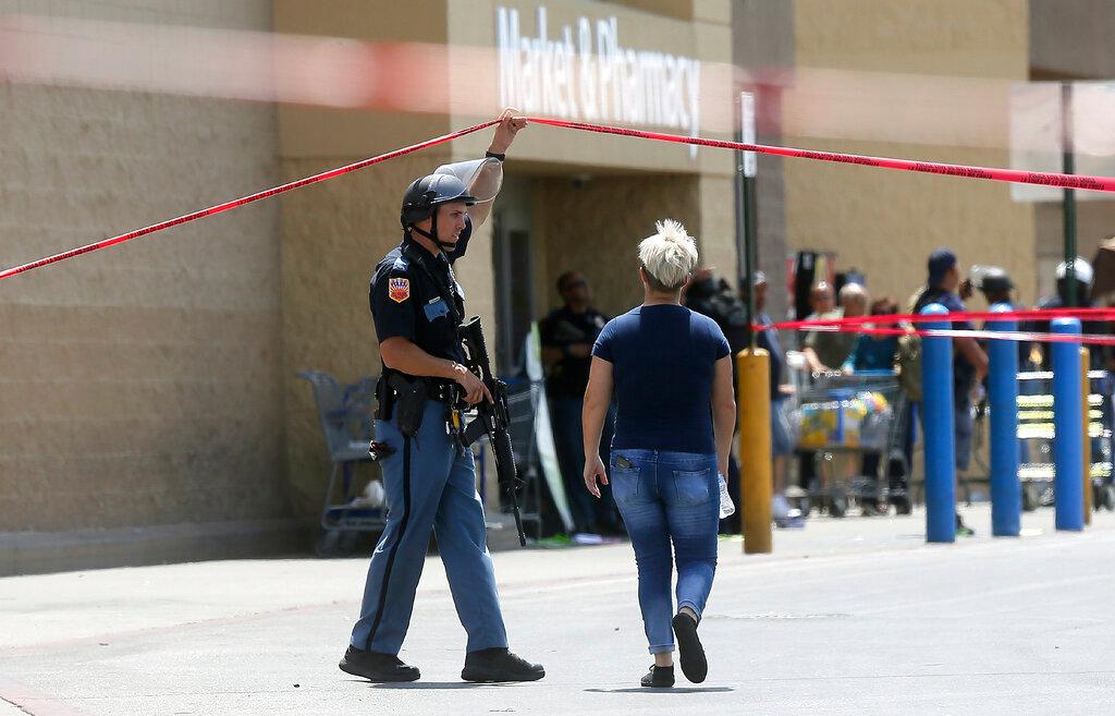 An employee crosses into the crime scene following a shooting at a Walmart in El Paso, Texas, on Aug. 3, 2019. (Mark Lambie/The El Paso Times via AP)
