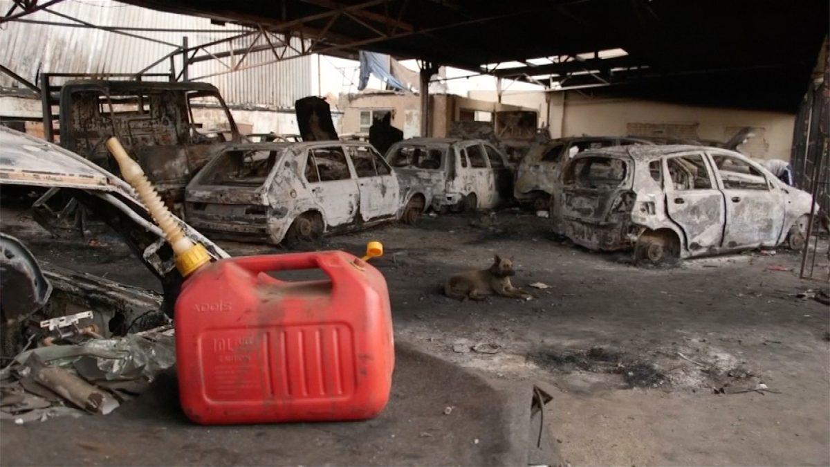 Raba Raba autospace car dealership owner, Basil Onuigbo walking through his burnt dealership shop, looking at shells of torched cars after violence erupted in South Africa. (Screenshot taken from video/Reuters)
