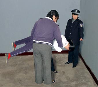 “The airplane” torture method. (Courtesy of Minghui.org)