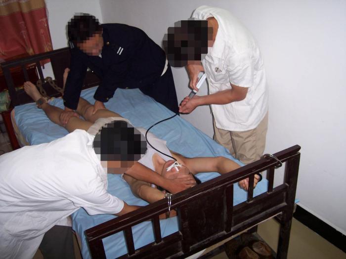 Torture reenactment of forced drug injections. (<a href="https://en.minghui.org/">Minghui.org</a>)