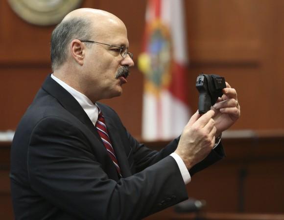 Assistant state attorney Bernie de la Rionda shows George Zimmerman's gun to the jury while presenting the state's closing arguments against Zimmerman during his trial in Seminole circuit court in Sanford, Fla., July 11, 2013. (AP Photo/Orlando Sentinel, Gary W. Green, Pool)