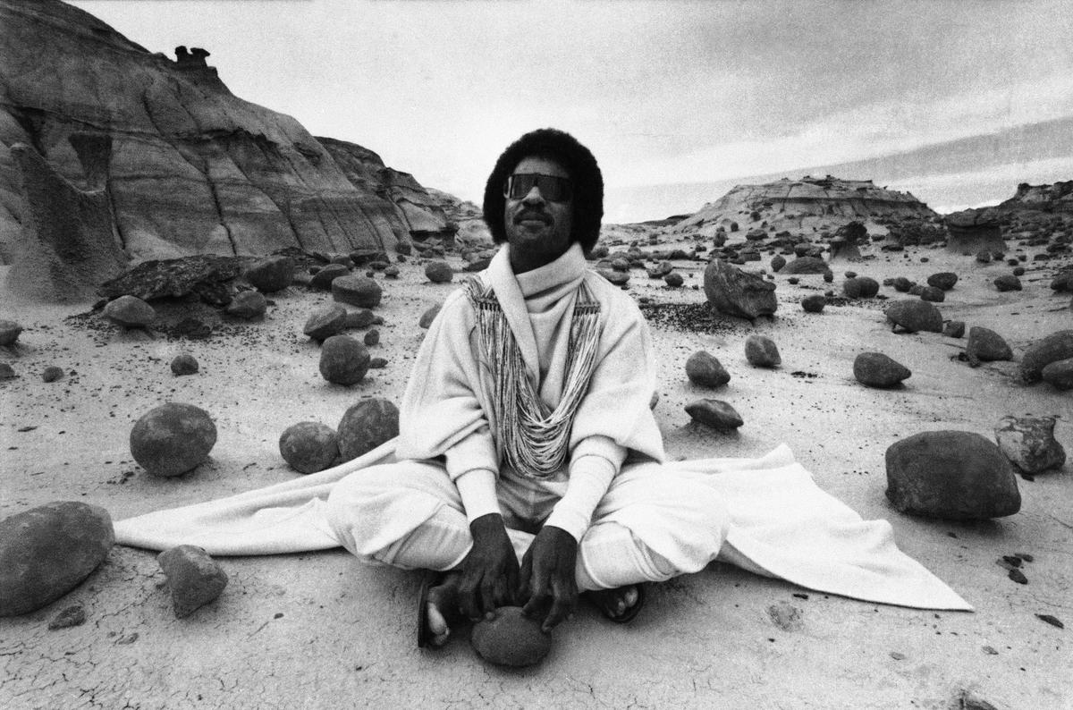 Musician Stevie Wonder sits amidst the eerie rocks of the Bisti Badlands in Farmington, New Mexico, Sept. 1, 1982, filming a commercial probably never seen in the United States. (AP Photo)