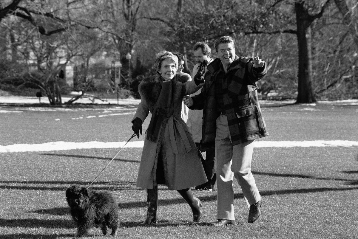 President Ronald Reagan and first lady Nancy Reagan wave after they arrived back on Sunday, Jan. 13, 1985 at the White House in Washington with their dog Lucky, a Bouvier des Flandres. (AP Photo/Ron Edmonds)