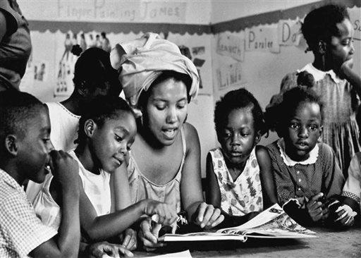 This 1966 photo provided by Maria Varela shows a member of the Student Nonviolent Coordinating Committee, SNCC, working with students in a Head Start program in Canton, Miss. The photo was taken by Varela, then a member of SNCC, and was one of the few Latinos involved in the black civil rights movement. (AP Photo/Maria Varela, File)