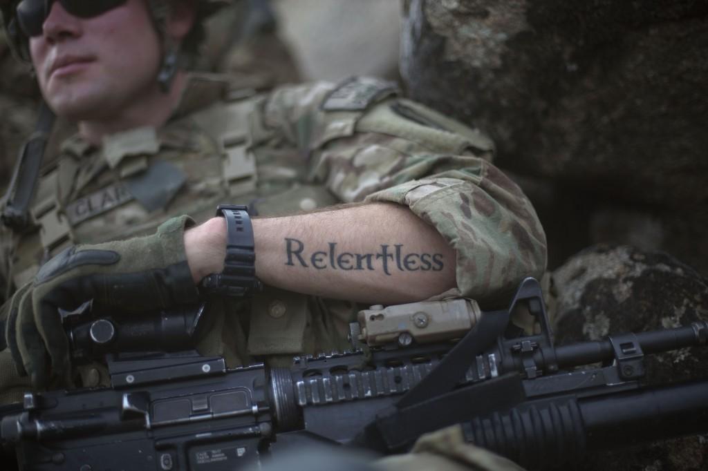 A tattoo reading "relentless" decorates the arm of Pfc. Mitchell Clark, 22, as he holds a security position during a patrol in Afghanistan, Sept. 8. (AP Photo/David Goldman)
