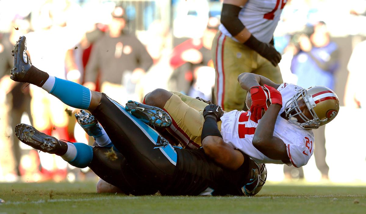 Frank Gore #21 of the San Francisco 49ers is tackled by Greg Hardy #76 of the Carolina Panthers after a 39-yard run in the fourth quarter of the NFC Divisional Playoff Game at Bank of America Stadium on January 12, 2014 in Charlotte, North Carolina. (Kevin C. Cox/Getty Images)