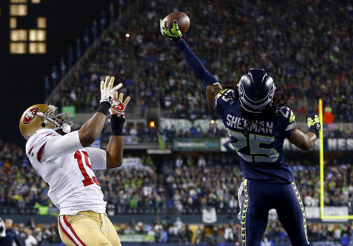 Cornerback Richard Sherman #25 of the Seattle Seahawks tips the ball up in the air as outside linebacker Malcolm Smith #53 catches it to clinch the victory. (Jonathan Ferrey/Getty Images)