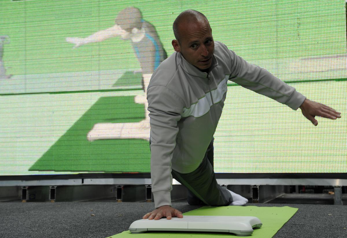 A fitness trainer demonstrates exercising with the Wii Fit, Japanese game console maker Nintendo's latest extension to its popular Wii game console, during an event to mark the Wii Fit launch in New York, May 19, 2008. (Emmanuel Dunand/AFP/Getty Images)