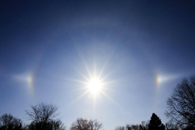 A sun dog, a phenomenon by which the sun's light appears as a halo around the sun, even creating spots of brightly shining light around the sun. (Shutterstock)