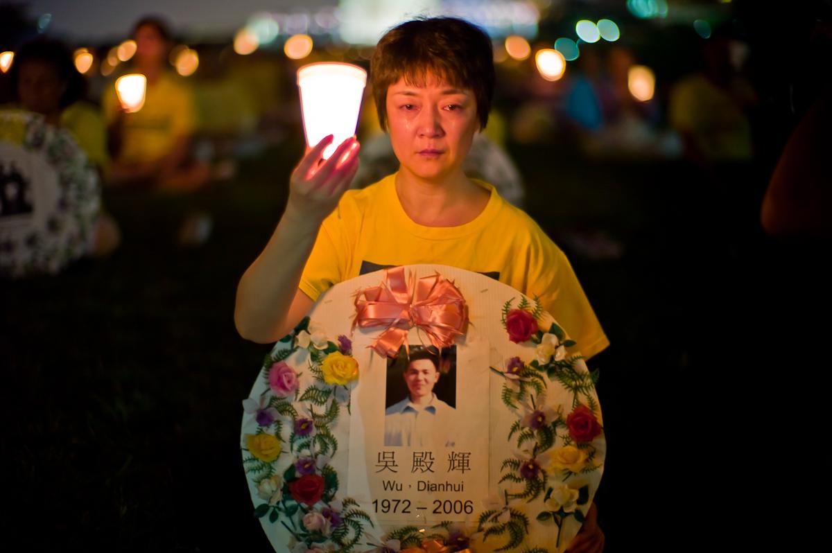 Falun Gong practitioner Jennifer Zeng, cries as she honors a victim of the persecution at the Washington Monument, July 22, 2010. (Mark Zou/Epoch Times)