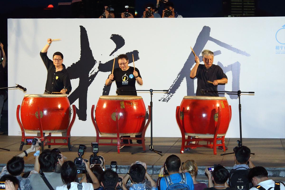 Three Occupy Central Movement organizers, (L to R) Chan Kin-man, Benny Tai Yiu-ting, and Chu Yiu-ming, beat drums to symbolize the start of civil disobedience to fight against the CCP's one-party dictatorship during a rally held on Tamar Park outside the Central Government Offices on Aug 31, 2014. (Poon/Epoch Times)