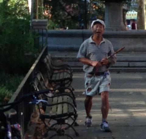 One of the alleged harassers of Falun Gong practitioners, taken in Manhattan, N.Y., September 2014, moments before he began to physically and verbally threaten the practitioners. The man swung his bamboo flute at one practitioner. (Lily Hung)