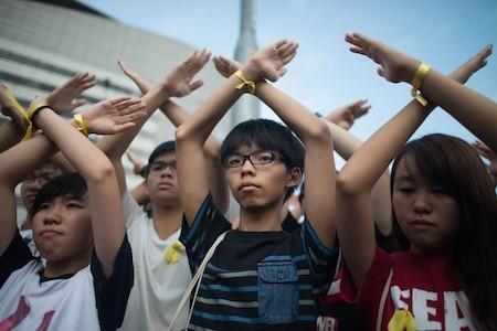 Student pro-democracy group Scholarism convenor Joshua Wong (C) makes a gesture at the Flag Raising Ceremony at Golden Bauhinia Square on Oct. 1, 2014. (Anthony Kwan/Getty Images)