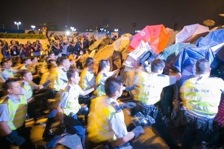 Police start to beat pro-democracy protesters after they successfully shutdown Lung Wo Road, one of the major roadways in Hong Kong, on Oct. 14, 2014. (Benjamin Chasteen/Epoch Times)
