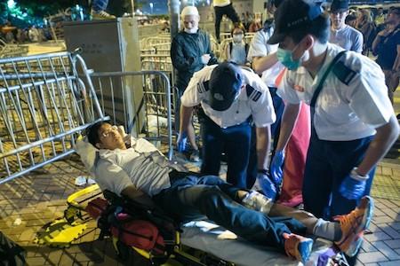 A man who was in injured by the police when they attacked the protesters, is put on a stretcher by medics in the Central District of Hong Kong on Oct. 14, 2014. (Benjamin Chasteen/Epoch Times)