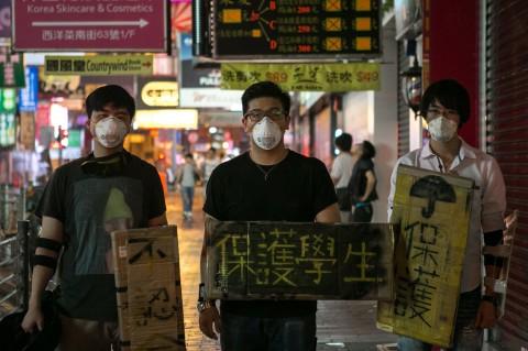 Pro-democracy protesters wear masks and carry signs shaped as shields in Mong Kok, Hong Kong on Oct. 7. Hacker groups online have been supporting the protesters by launching cyberattacks on the Chinese regime. (Benjamin Chasteen/Epoch Times)