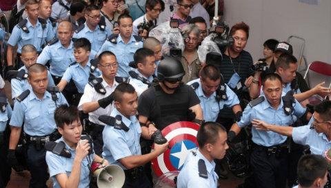 Yes, it takes THAT many cops to arrest the Star Spangled Man. (Apple Daily/Screen shot)