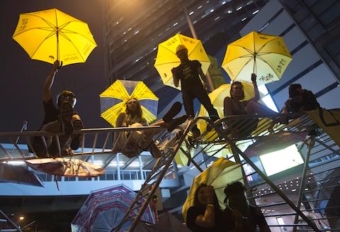 Protesters pose for photographs on a barricade at the occupied area outside government headquarters in Hong Kong Wednesday, Dec. 10, 2014. (AP Photo/Kin Cheung)