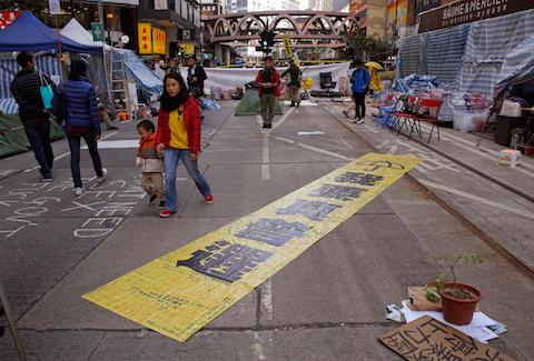 The yellow banner reads " I want genuine universal suffrage." is displayed by protesters in the Causeway Bay shopping district, one of the occupied areas in Hong Kong Saturday, Dec.13, 2014. (AP Photo/Kin Cheung)