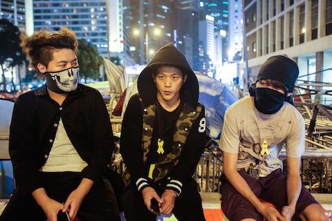 (L-R) Homes Sin, Jack, and Victor are the main protesters in charge of organizing and guarding the barricades on the out skirts of the main "Umbrella Square," site in the Central District of Hong Kong on Oct 27, 2014. (Benjamin Chasteen/Epoch Times)