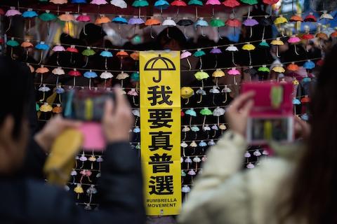 People take photos of an installation of paper umbrellas -- symbols of the pro-democracy protests in Hong Kong -- on a blockaded road in the Causeway Bay district of Hong Kong on December 14, 2014. (Alex Ogle/AFP/Getty Images)