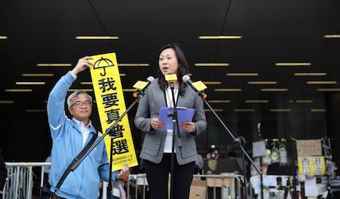 A government official (C) advises pro-democracy protesters that a deadline had ended to leave an area in front of the legislative council building in the Admiralty district of Hong Kong on December 15, 2014. (Isaac Lawrence/AFP/Getty Images)