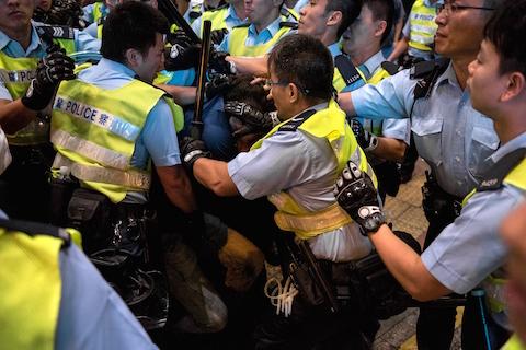 Police officers surround a pro-democracy protester (C) and restrain him in the Mongkok district of Hong Kong on November 26, 2014. (Alex Ogle/AFP/Getty Images)