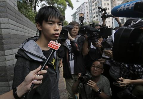 Prominent Hong Kong student protest leader Joshua Wong talks to reporters after being thrown eggs by two men outside a court in Hong Kong Thursday, Nov. 27, 2014. (AP Photo/Vincent Yu)