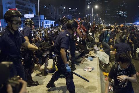 Police charge towards pro-democracy protesters near the government headquarters in the Admiralty district of Hong Kong early on December 1, 2014. (Dale de la Rey/AFP/Getty Images)