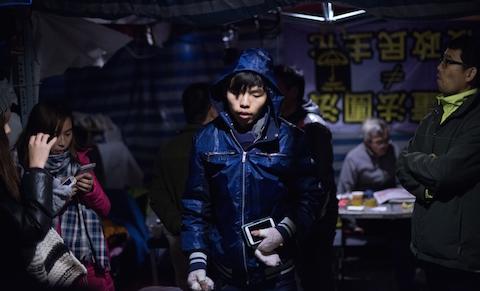 Leader of the student group Scholarism, Joshua Wong (C) arrives for a press conference at the pro-democracy movement's main protest site in the Admiralty district of Hong Kong on Dec. 4, 2014. (Johannes Eisele/AFP/Getty Images)