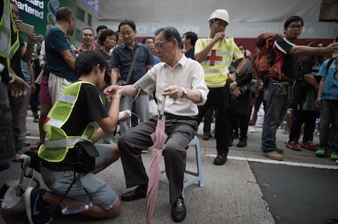 An elderly man who was making a speech has his blood pressure checked after becoming overwhelmed while speaking by first aid workers in the campsite of pro-democracy protesters in the Mongkok district of Hong Kong on October 24, 2014. (Nicolas Asfouri/AFP/Getty Images)