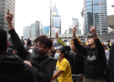 Pro-democracy protesters gesture towards police near the government headquarters in the Admiralty district of Hong Kong on December 1, 2014. (Dale de la Rey/AFP/Getty Images)