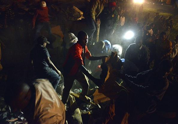 Civilian volunteers help carry away debris from the scene of a collapsed multi-storey residential building, January 04, 2014 in densely populated Huruma estate area of Kenyan capital, Nairobi. (TONY KARUMBA/AFP/Getty Images)