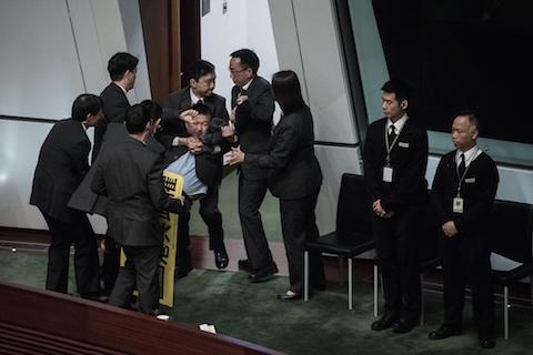 Pro-democracy lawmaker Raymond Chan (L) is taken away after he interrupted the policy address of Hong Kong Chief Executive Leung Chun-ying by staging a protest in the legislative council in Hong Kong on Jan. 14, 2015. (Philippe Lopez/AFP/Getty Images)
