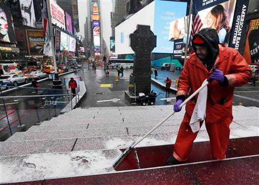 Francisco Mathurine, of the Times Square Alliance, clears snow from the steps in Father Duffy Square in New York, Monday, Jan. 26, 2015. (AP Photo/Richard Drew)