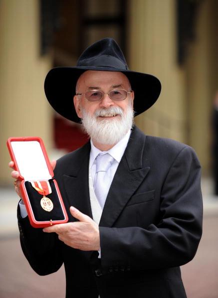 Sir Terry Pratchett poses for photographs after he was knighted by Queen Elizabeth II at Buckingham Palace on February 18, 2009 in London, England. (Photo by Ian Nicholson - WPA Pool/Getty Images)