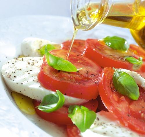 Do not buy light olive oil or a blend; it isn't virgin quality. Buy extra virgin olive oil. (<a href="http://www.shutterstock.com/pic-134768954/stock-photo-pouring-olive-oil-over-tomato-mozzarella.html?src=-pMQXyJPJa5EkkxZtDMOww-1-1" target="_blank">Shutterstock</a>)
