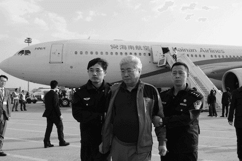 An Huimin (C) is brought back to China by a security detail on March 28, 2015. (Screen shot/ccdi.gov.cn)