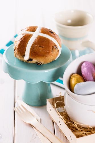 The average 80-gram hot cross bun contains 1,070 kilojoules. (<a href="http://www.shutterstock.com/pic-256264102/stock-photo-tasty-easter-cross-bun-served-on-a-cupcake-stand-on-white-wooden-background.html?src=pp-same_artist-180433421-4oxiLxMTnjtnyN6vv2mWvQ-2" target="_blank">Shutterstock</a>)