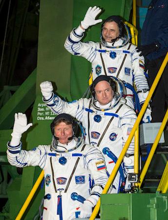 Russian cosmonaut Mikhail Kornienko of the Russian Federal Space Agency (Roscosmos (Top), NASA astronaut Scott Kelly (C), and Russian cosmonaut Gennady Padalka of Roscosmos wave farewell as they board the Soyuz TMA-16M spacecraft ahead of their launch to the International Space Station, in Baikonur, Kazakhstan, on March 27, 2015. (NASA)