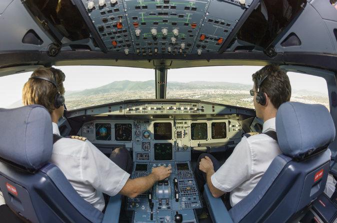 Pilots in an airplane cockpit via Shutterstock*