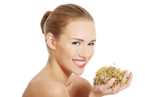 Both the quality of the protein and the fiber content of beans, nuts, seeds, and grains improve when sprouted. (<a href="http://www.shutterstock.com/pic-235631443/stock-photo-nude-woman-holding-sunflower-sprouts.html?src=LWRWZO_BufDk1M4gDZcKeA-1-6" target="_blank" rel="noopener">Shutterstock</a>)
