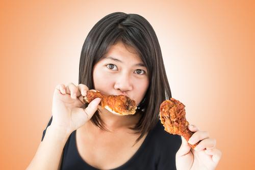 If you're on a low-carb diet, then it may be a better choice to go for the fattier cuts of the chicken, like the wings and thighs. (<a href="http://www.shutterstock.com/pic-123391558/stock-photo-hot-and-spicy-girl-with-fried-chicken.html?src=Epg8GA0Wt0M3g-928tbL_Q-1-52" target="_blank">Shutterstock</a>)