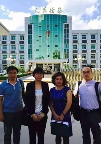 (2nd L-R) Lawyers Wang Yu, Hu Guiyun, and Feng Yanqiang post for a picture outside Sanhe People's Court, Hebei Province, China on July 2, 2015. (Screen shot)