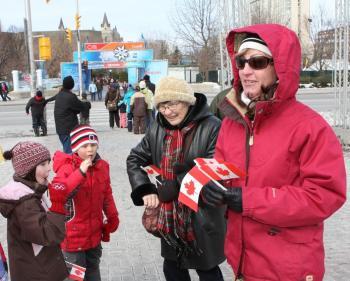 A family attends the flag-raising ceremony outside Ottawa City Hall to celebrate National Flag of Canada Day, Feb. 15, 2010. (The Epoch Times)