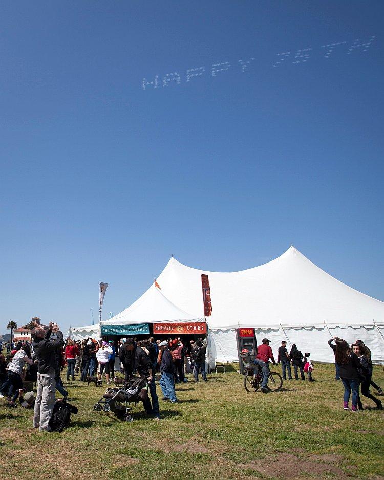 People stop to see and photograph "Happy 75th" written in stars in the sky. (Deborah Yun/The Epoch Times)